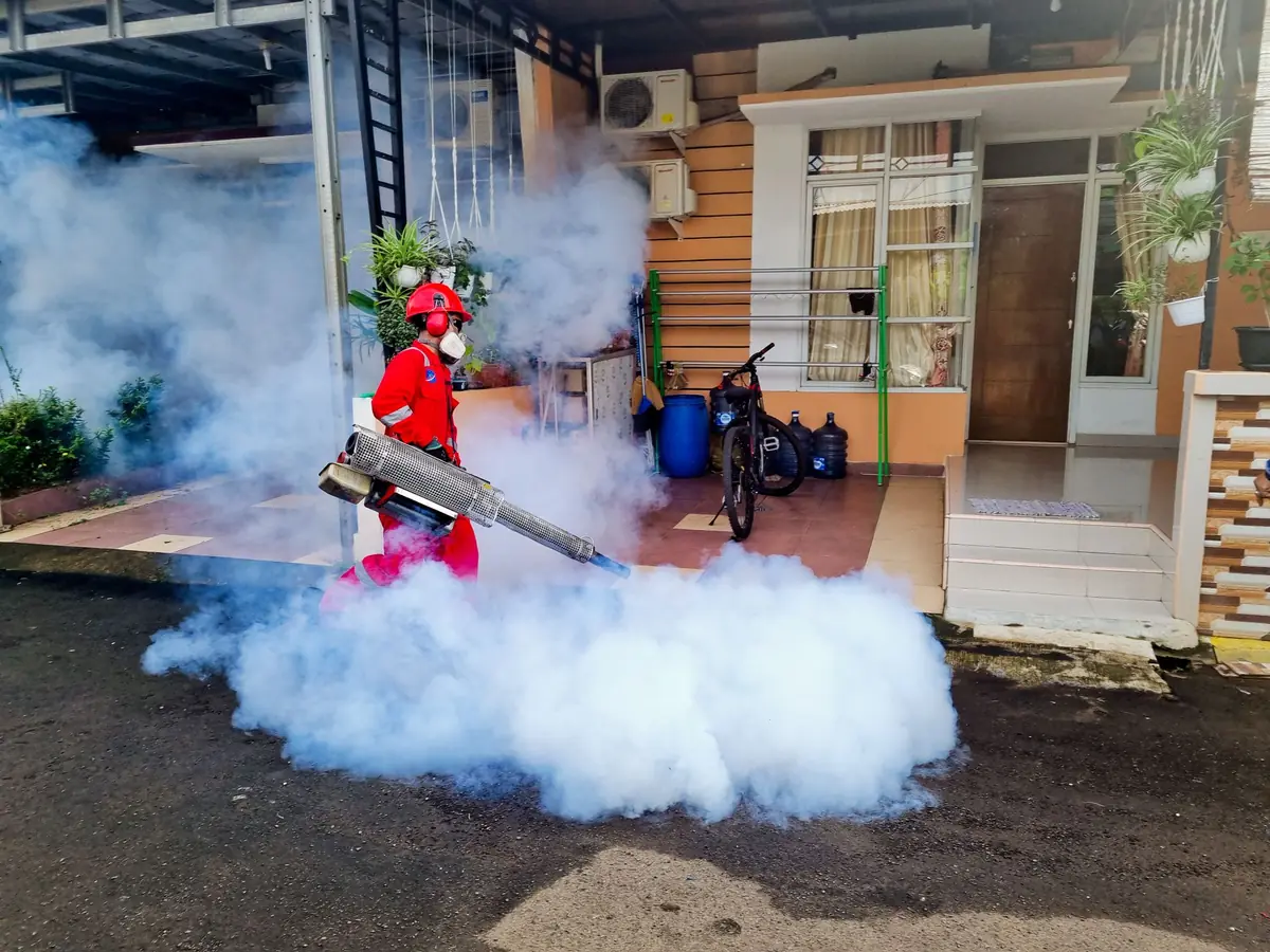 Technician fogging outside a farm building